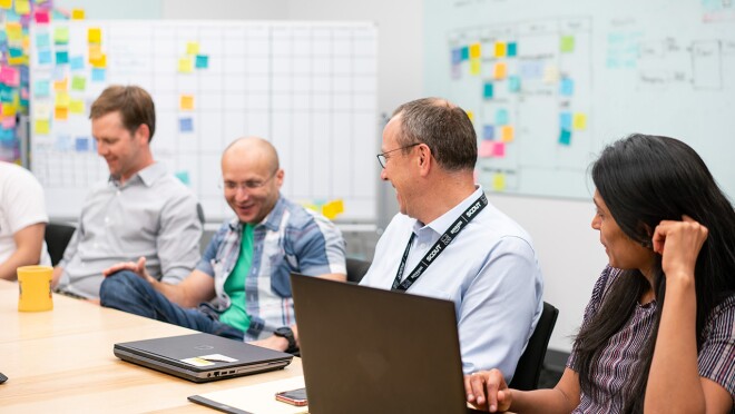 四个人坐在亚马逊办公室的一张桌子旁