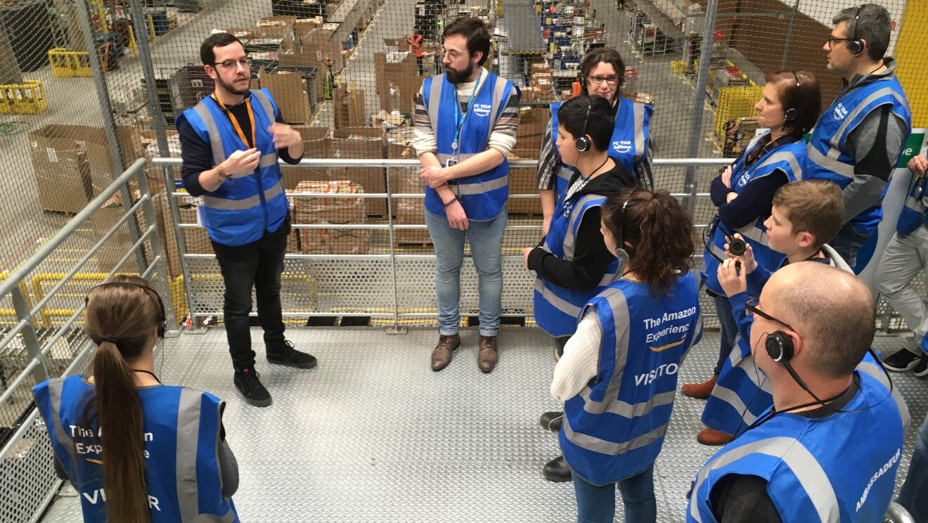 Un employé Amazon accompagnant un groupe lors d'une visite d'un centre de distribution