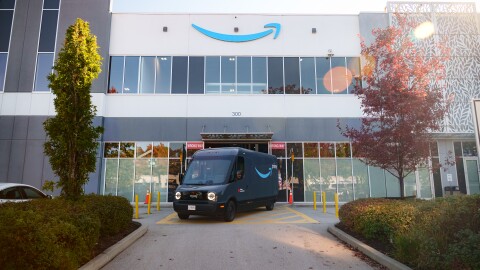Image of an Amazon x Rivian delivery van parked in front of an Amazon warehouse