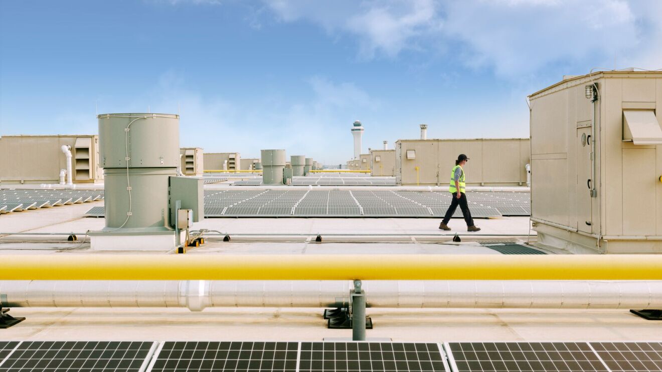 carbon-free energy, rooftop view of solar installation with airport control tower in background
