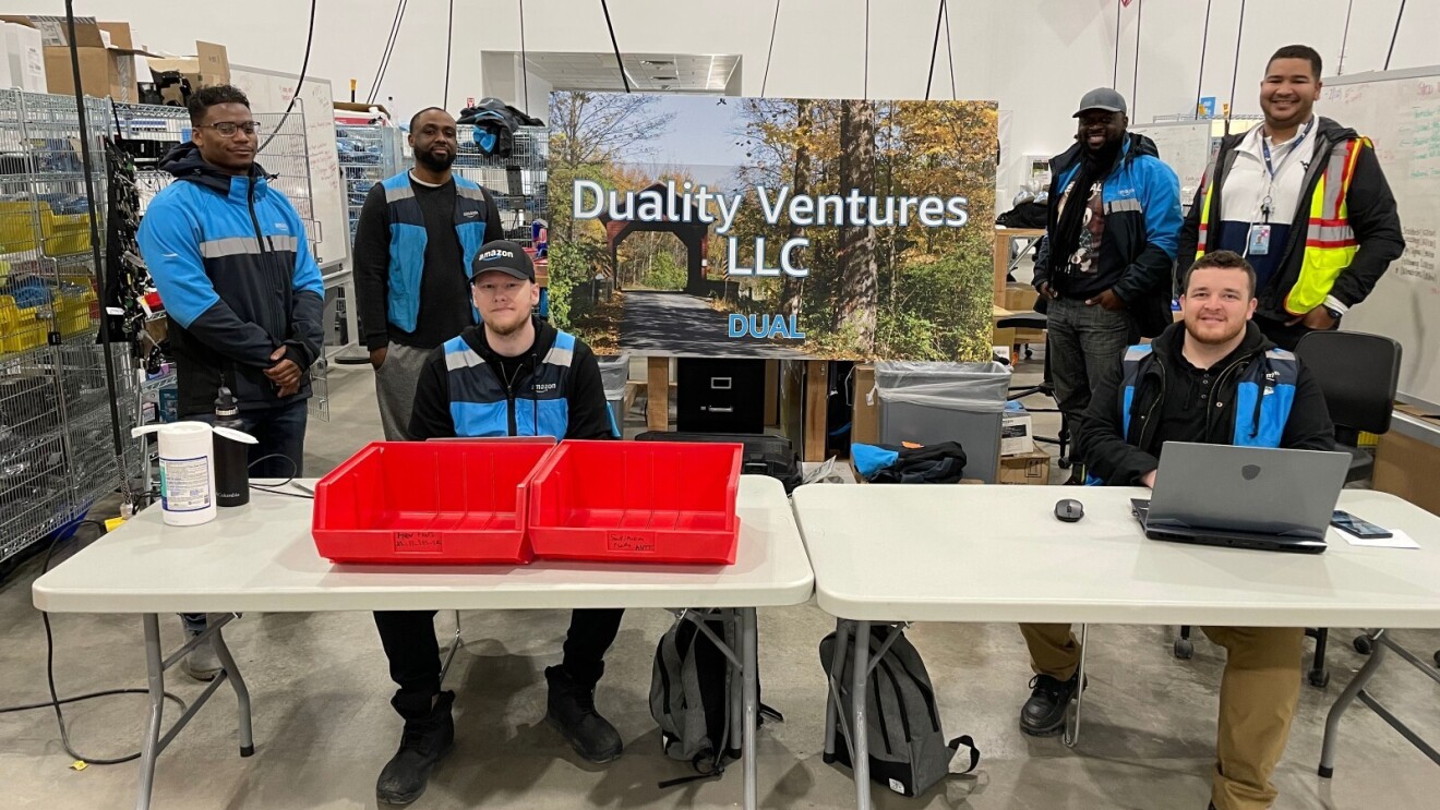 The Duality Ventures team poses for a picture wearing their Amazon uniforms.