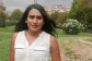 Karla Elena Márquez posa mirando a cámara en los jardines del Palacio Real de Barcelona, con una camisa blanca sin mangas y la melena al viento. 