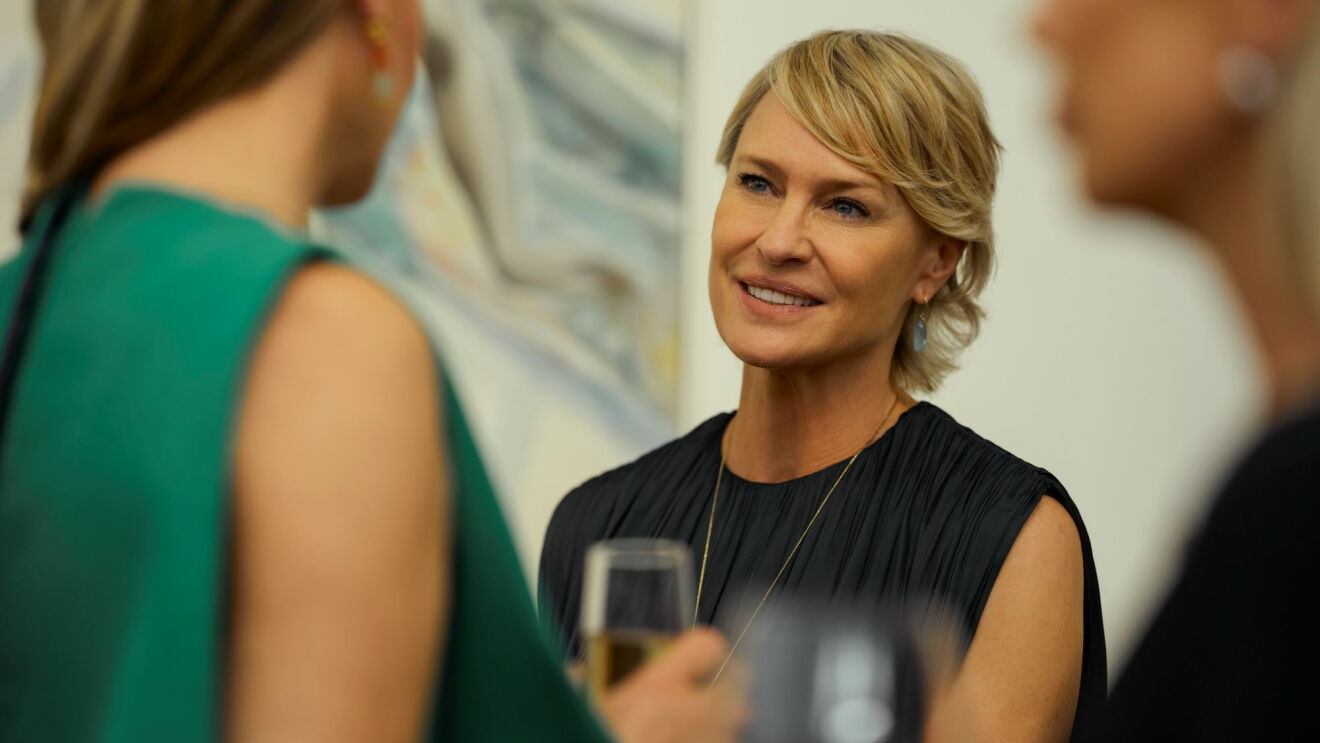 Robin Wright smiles across a crowded room