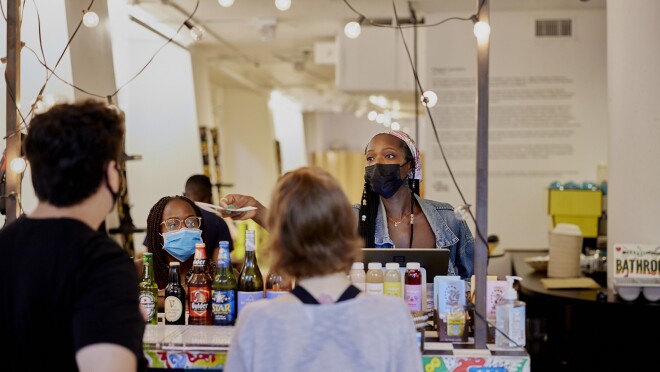 一个女人的形象将收据交给一个男人在一家餐馆的柜台。