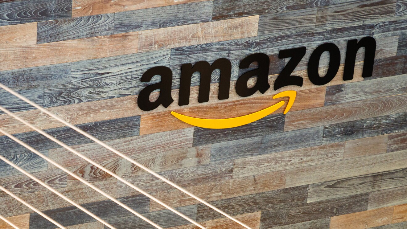 The word amazon in black lettering, with the Amazon Smile in yellow, on a wood plank wall at Amazon's Seattle HQ. 