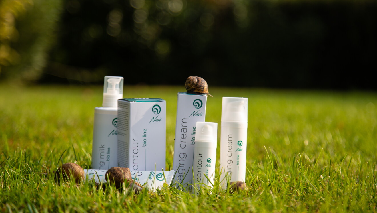 I prodotti di Nuvò Cosmetic in un prato con lumache
