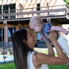 A woman holding her baby up in the air and smiling