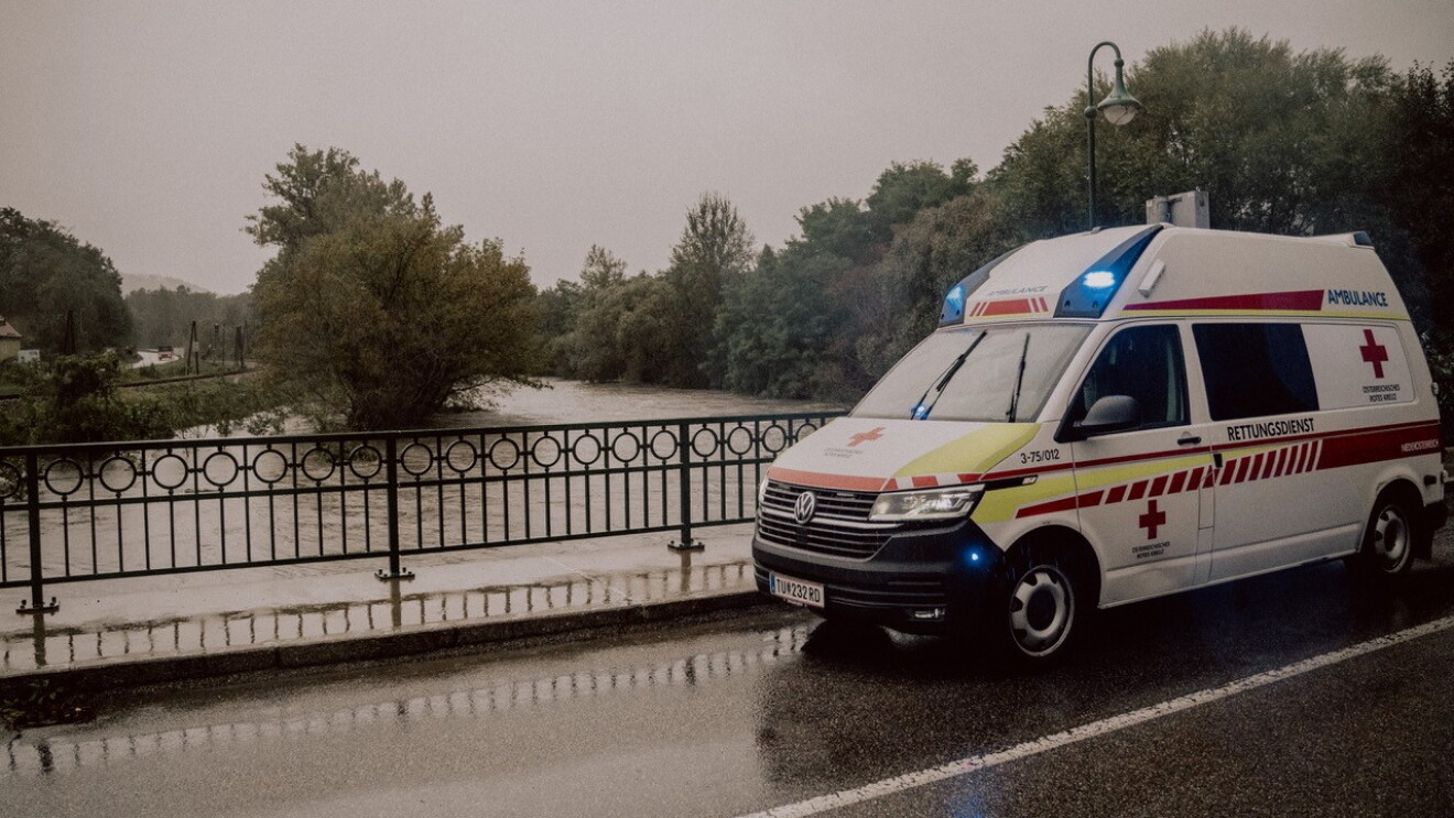 Ein Bild von einem Rettungswagen neben einem Hochwassergebiet.