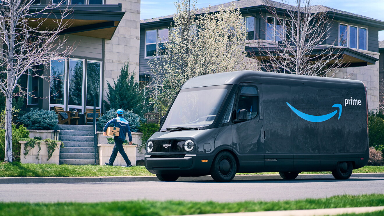 Amazon delivery driver walks from his delivery van toward a house while holding a package.
