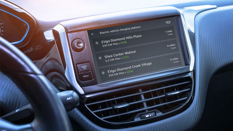 A photograph of the dashboard of a vehicle, displaying on a screen the three closest electric vehicle charging stations of the car.