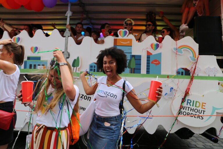 Feiernde Amazon Mitarbeiter vor dem Glamazon-Wagen auf dem Christopher Street Day in München.