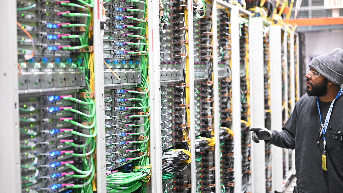 A photo of a data center technician observing servers inside an AWS Data Center. 