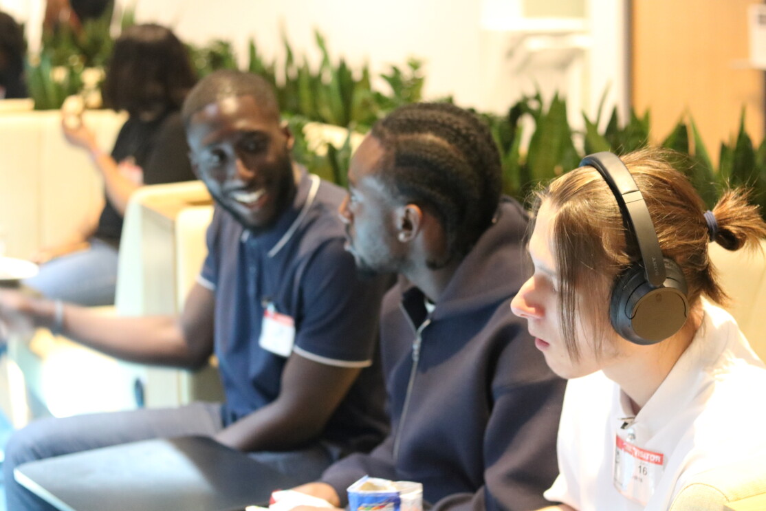 Students engaged in discussion, one wearing headphones