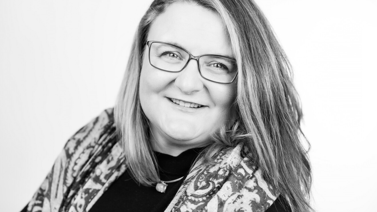 Amazon Europa-Direktorin Ingrid Ebner im sw Porträt: Eine Frau mit halblangen blonden Haaren und Brille blickt lächelnd in die Kamera.
