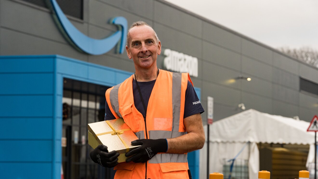 Phil Hayden holding a present outside his Amazon site