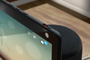 An image of an Echo Show device sitting on a table with a prominent view of the buttons on the top.