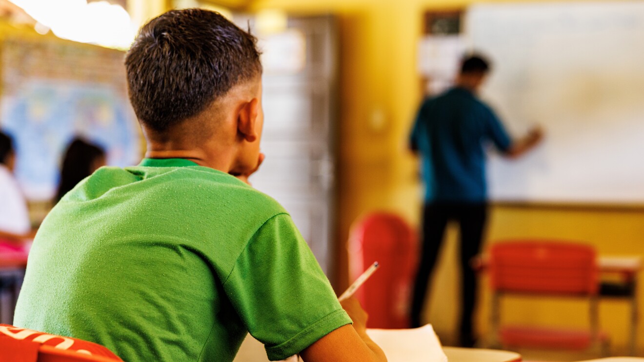 Hombre en una aula tomando nota. 