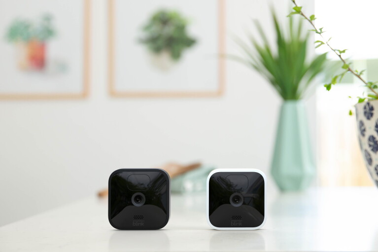 Two Blink indoor/outdoor cameras on a countertop.