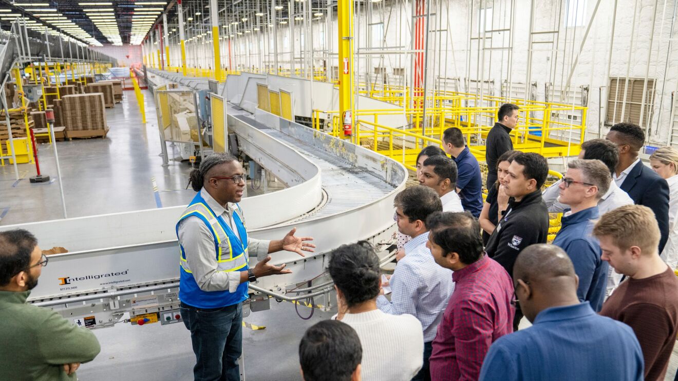 Amazon employee leads group of visitors on a fulfillment center tour in Kent, Washington, USA.