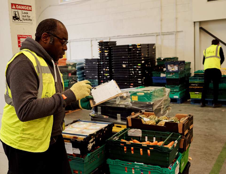 A volunteer checks stock at The Felix Project's warehouse
