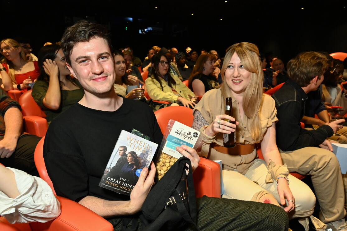 Two fans at The Wheel of Time screening showing the items in the swag bag