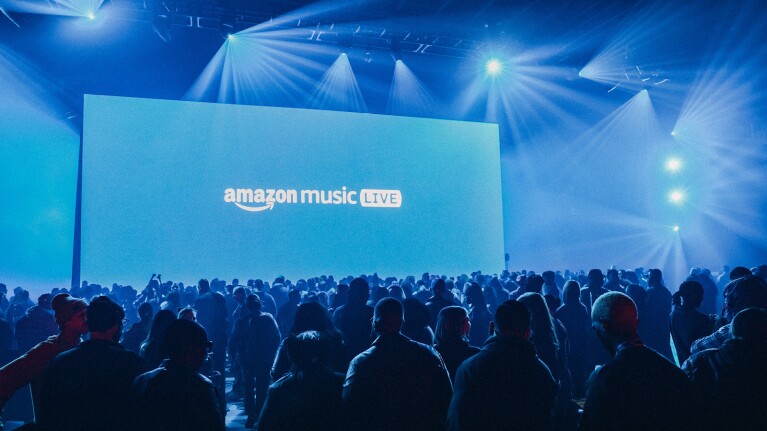 An image of a concert with a blue screen that reads "Amazon Music Live."