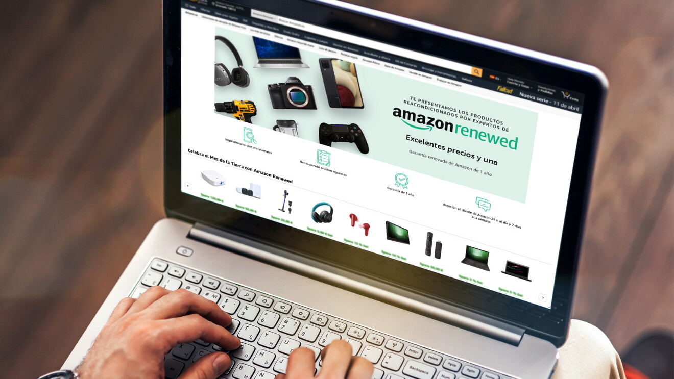Computadora portátil junto a un teléfono móvil y una taza de café, mostrando el escaparate de Amazon Renewed