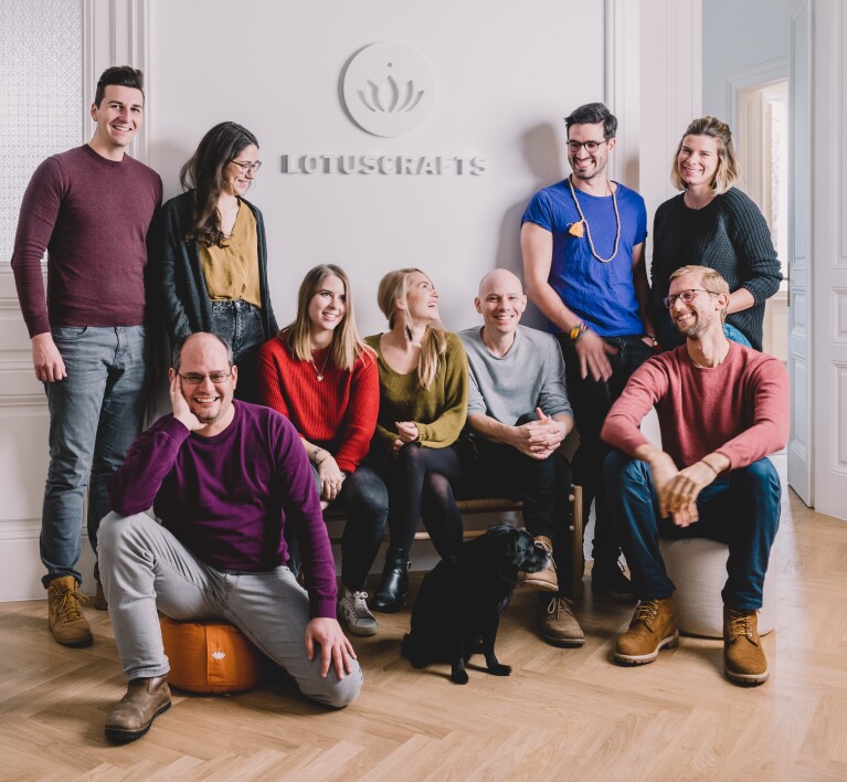 Teamfoto des Verkäufer Lotuscrafts aus Wien mit Hund vor dem Firmenlogo