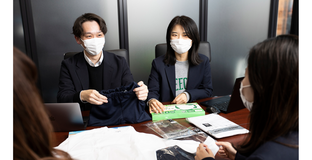 商品を手にミーティングしている写真