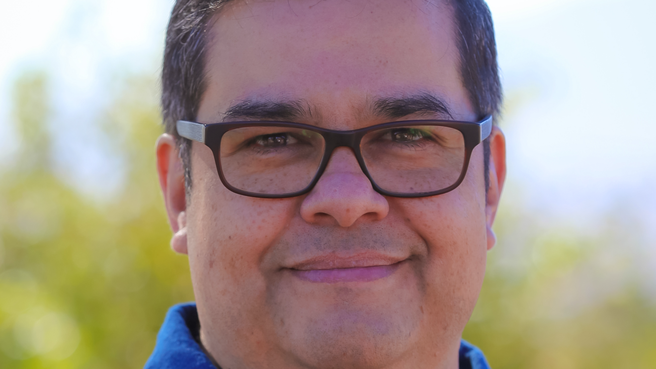 An image of a man smiling for a headshot photo.