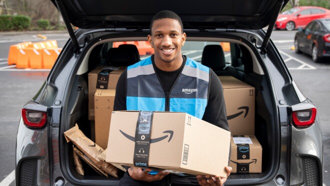 Una foto del mariscal de campo Michael Penix Jr., sentado en el borde del maletero de un automóvil, sosteniendo una caja de entrega de Amazon.
