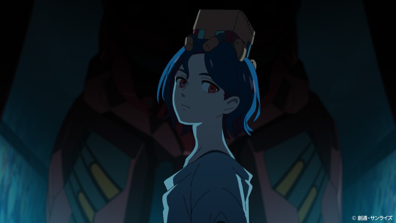 薄暗い場所にいる、頭に黄色い箱のようなものを載せてこちらを向く青い髪と赤い目をした人物(シュウジ・イトウ)。その後ろに赤い巨大なモビルスーツのようなものの一部が見える