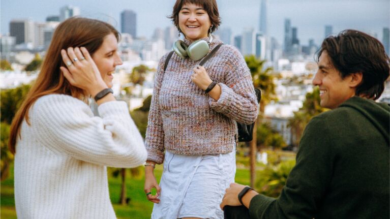 Friends enjoying a sunny day with San Francisco skyline in background wearing Bee Pioneer