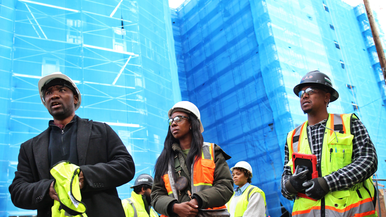A photo of fellows from the Amazon Housing Equity Fund’s Housing Equity Accelerator Fellowship (HEAF) program, in front of affordable housing properties under construction in Seattle, Washington.