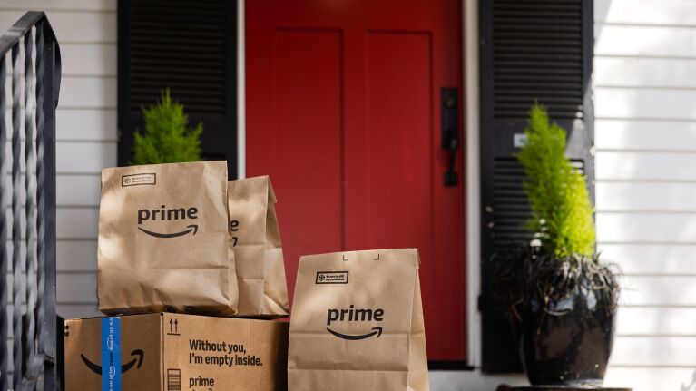 Amazon Prime packages on doorstep in front of red door