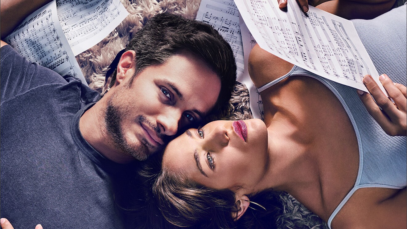 莫扎特在丛林中系列作品。一个男人和一个女人躺在地上,头上是触摸,用他的身体转向左,她转向右边。他们包围乐谱