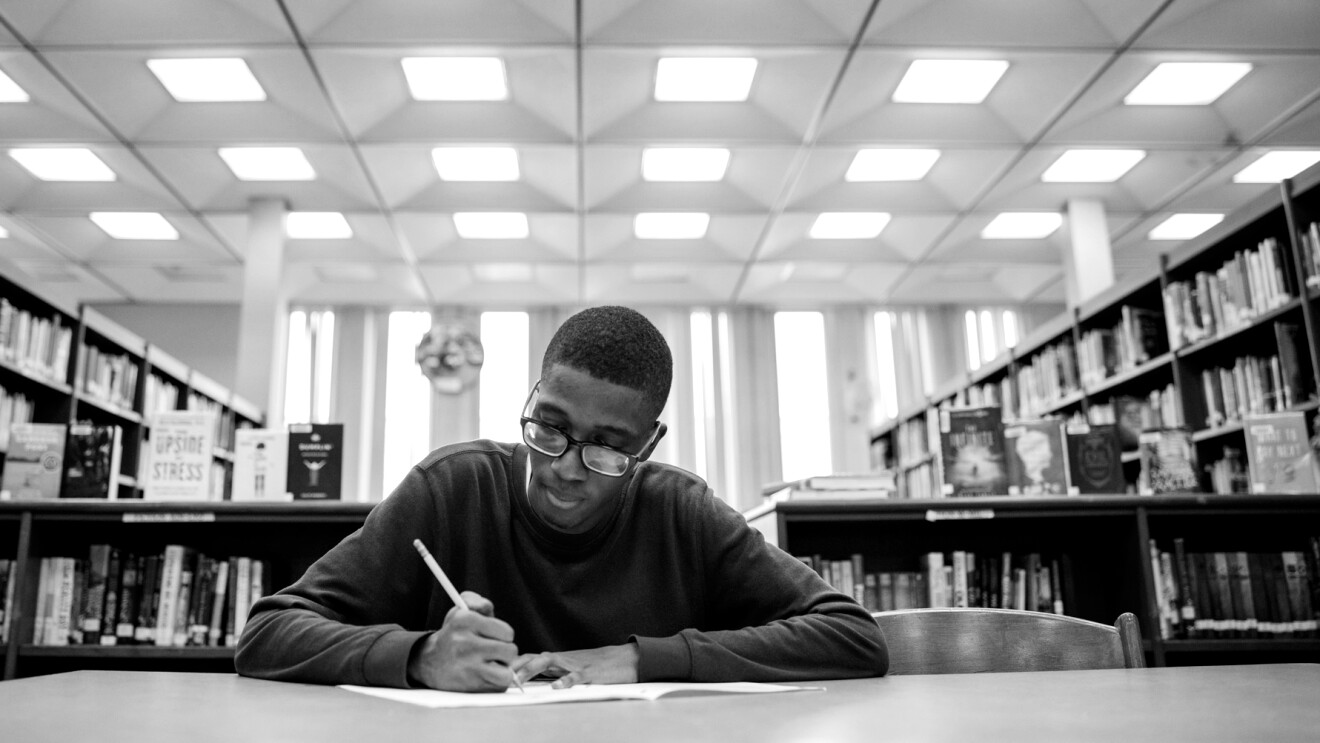 Amazon Future Engineer student studying at a desk in the library.