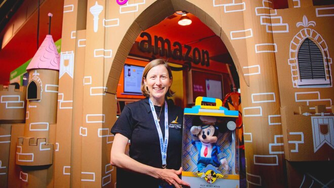 一张亚马逊员工拿着毛绒米老鼠飞行员玩具的图片。