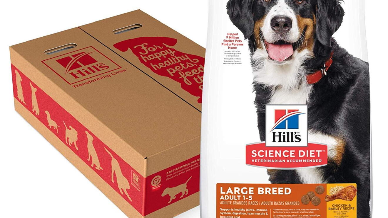 A bag of Hill's dog food next to a cardboard box decorated with silhouettes of dogs.