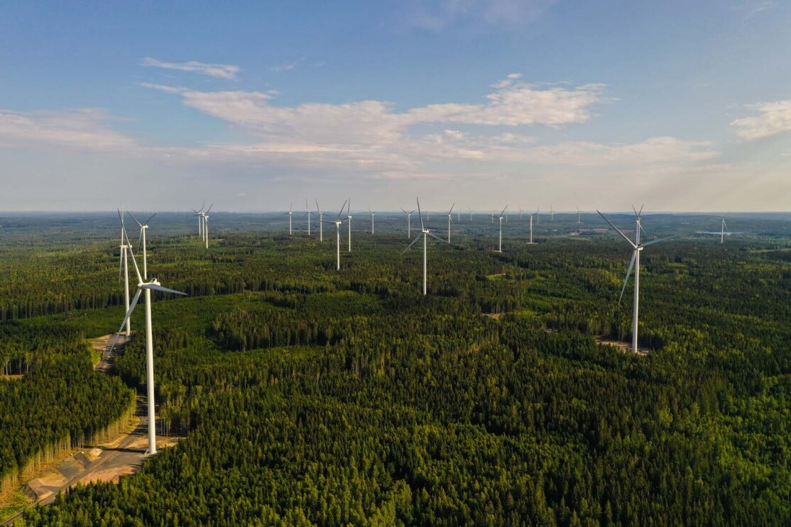 Aerial photo of wind farm turbines spread across the forest in Bäckhammar, Sweden.