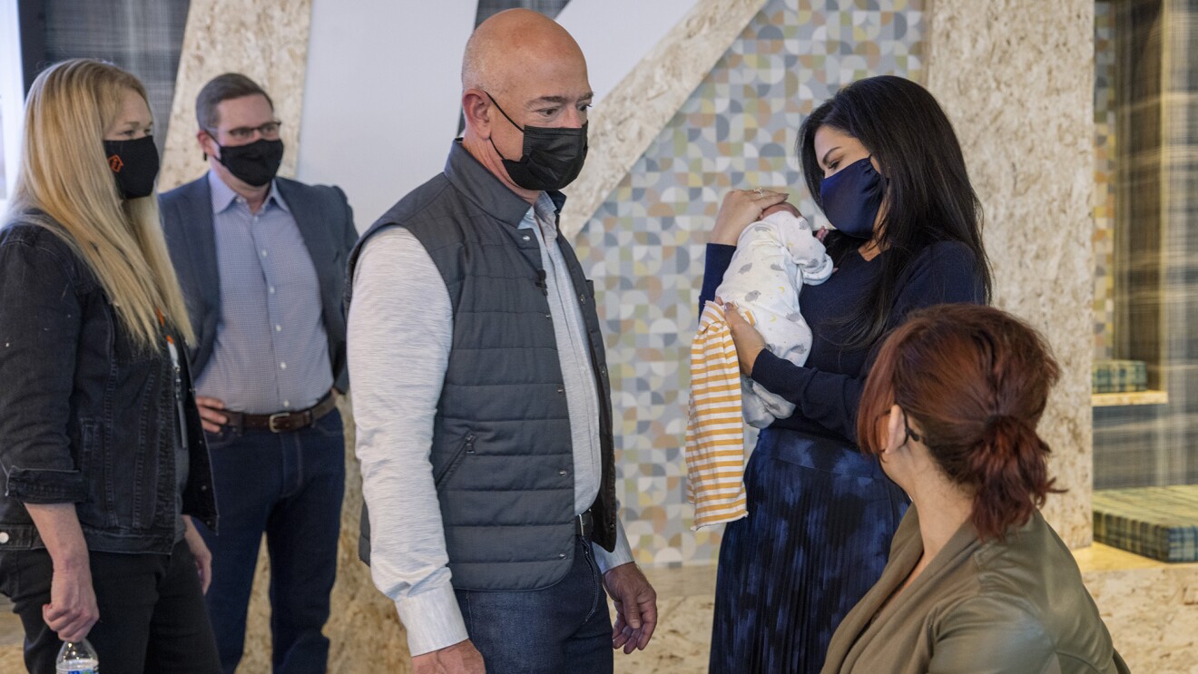 An image of Lauren holding a baby at the Mary's Place Family Center while others are gathered around.