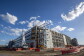 An image of a partially built Amazon fulfillment center with construction barriers and equipment around it. There is a blue sky overhead.