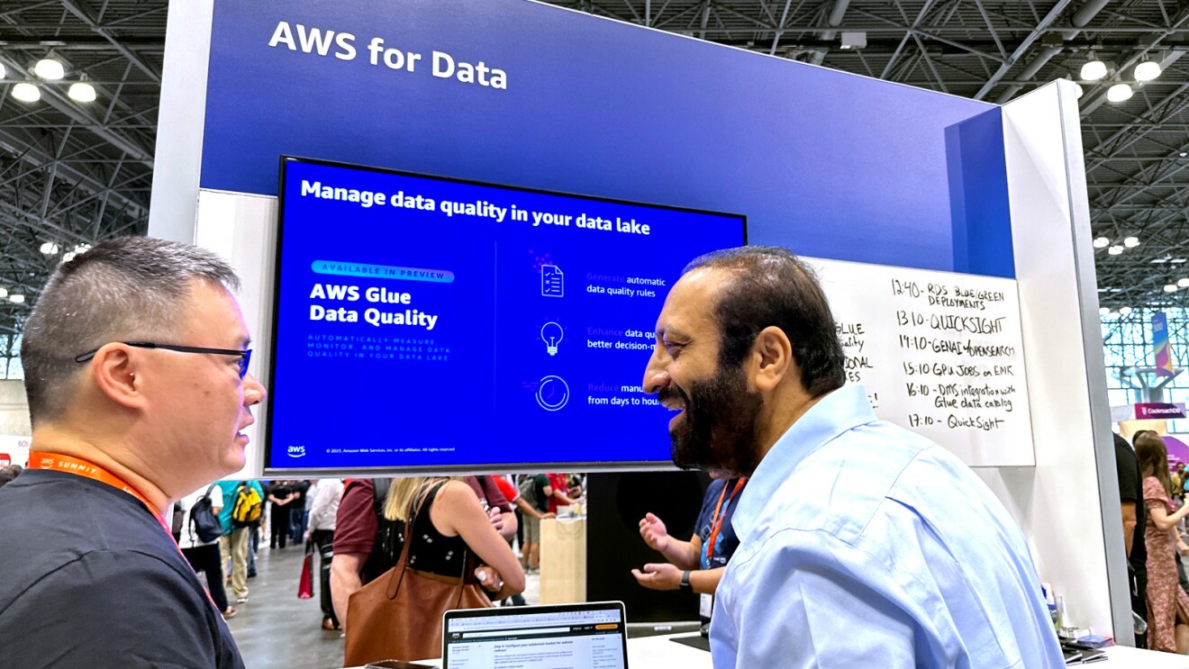 A photo of two attendees at AWS NY Summit talking.