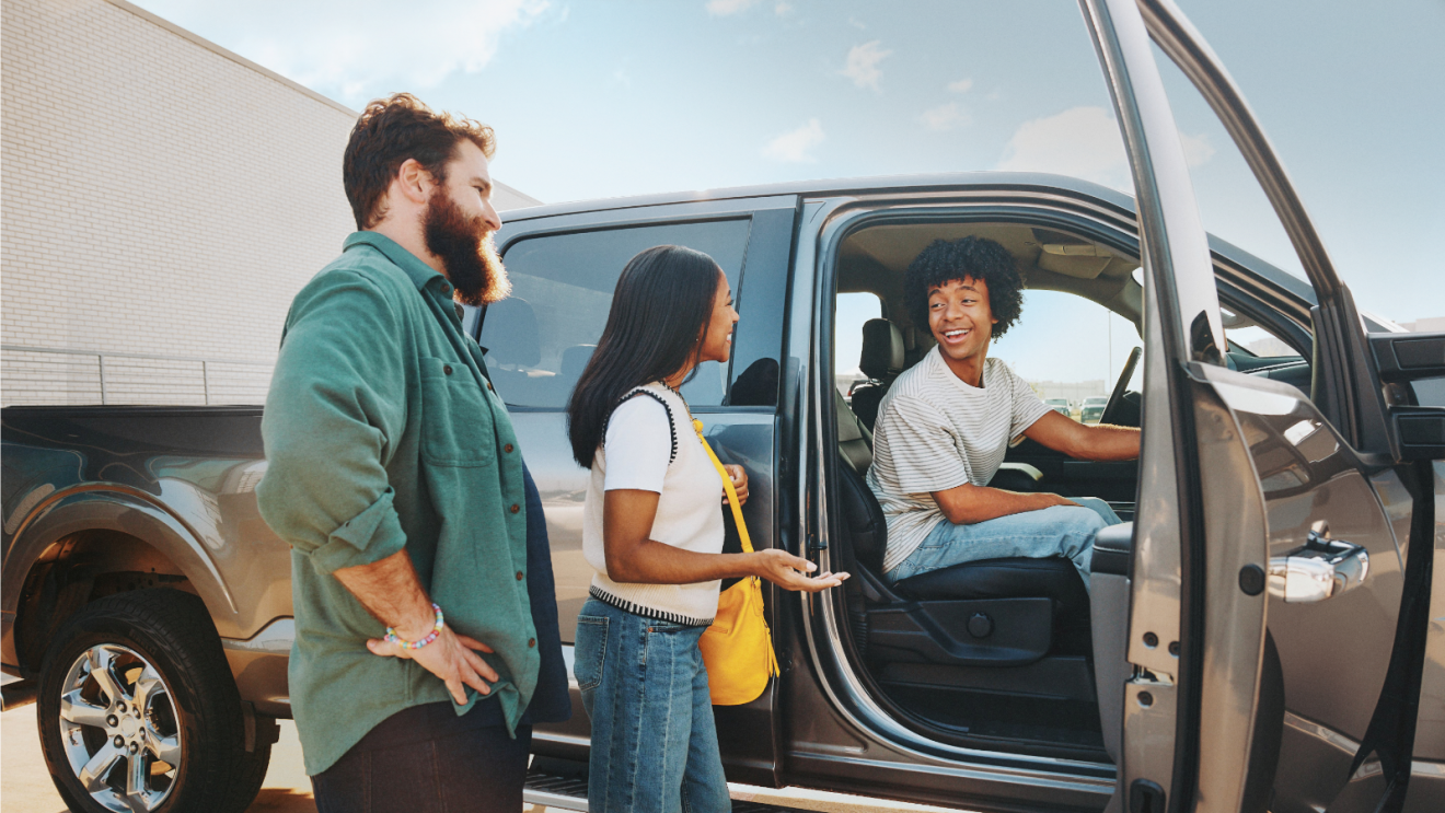 Family posing outside a vehicle after having purchased via Amazon Autos