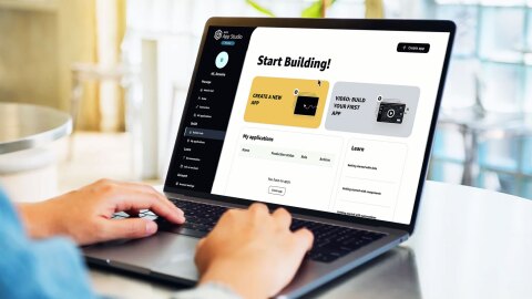 Dos manos trabajando en un ordenador con AWS App Studio.