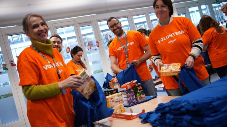 Um bedürftige Familien über die Feiertage zu unterstützen, haben mehr als 700 Mitarbeiter:innen an 30 Standorten von Amazon aus ganz Deutschland zusammen mit verschiedenen gemeinnützigen Organisationen Lebensmittelpakete gepackt.