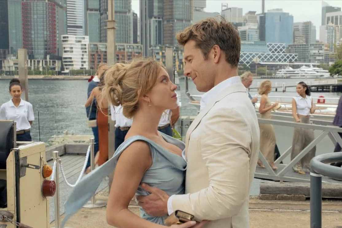 A couple standing together on a dock, looking deep into each others eyes