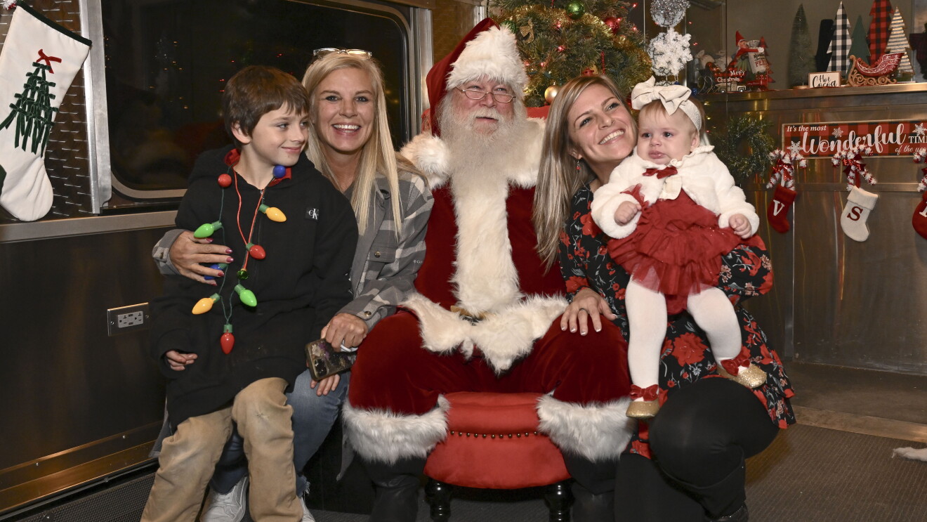 Family posing with Santa Claus in festively decorated room