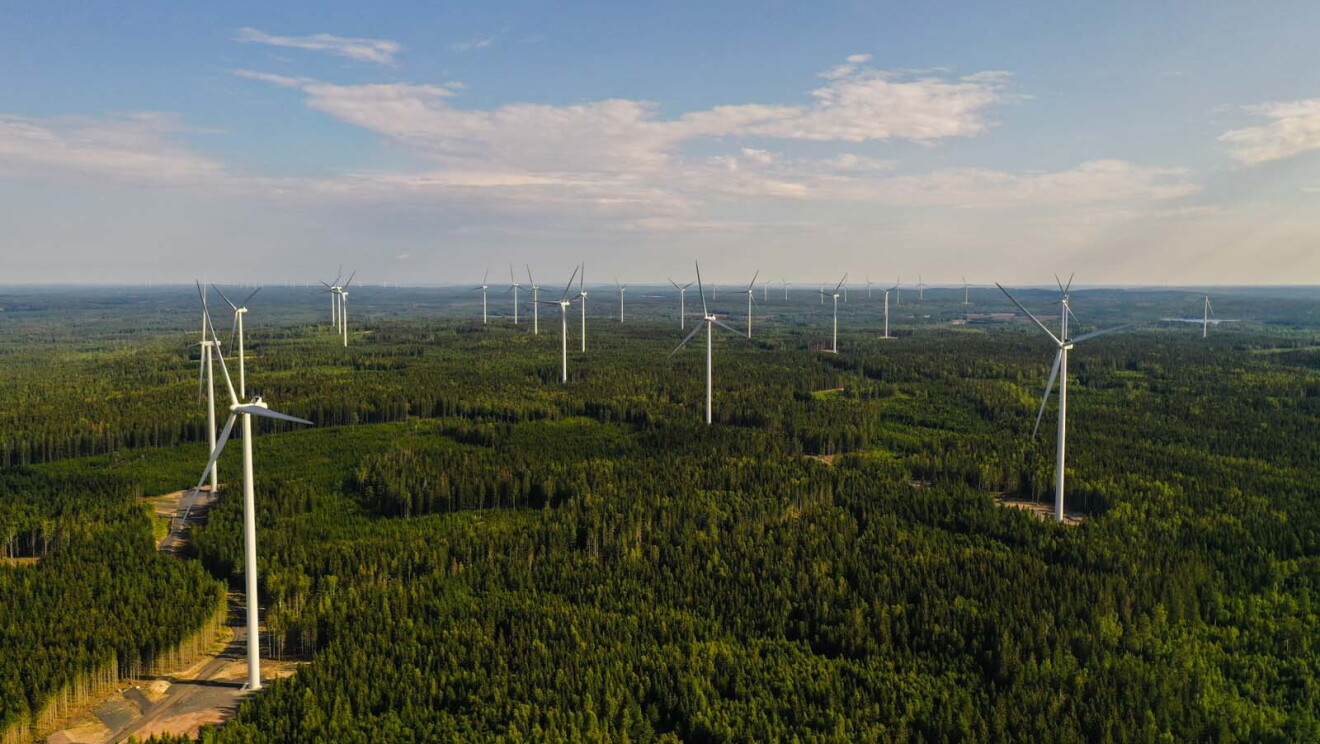 Aerial photo of wind farm turbines spread across the forest in Bäckhammar, Sweden.