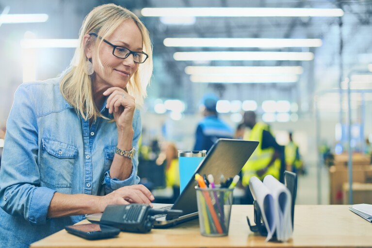Eine Frau mit Brille an einem Laptop